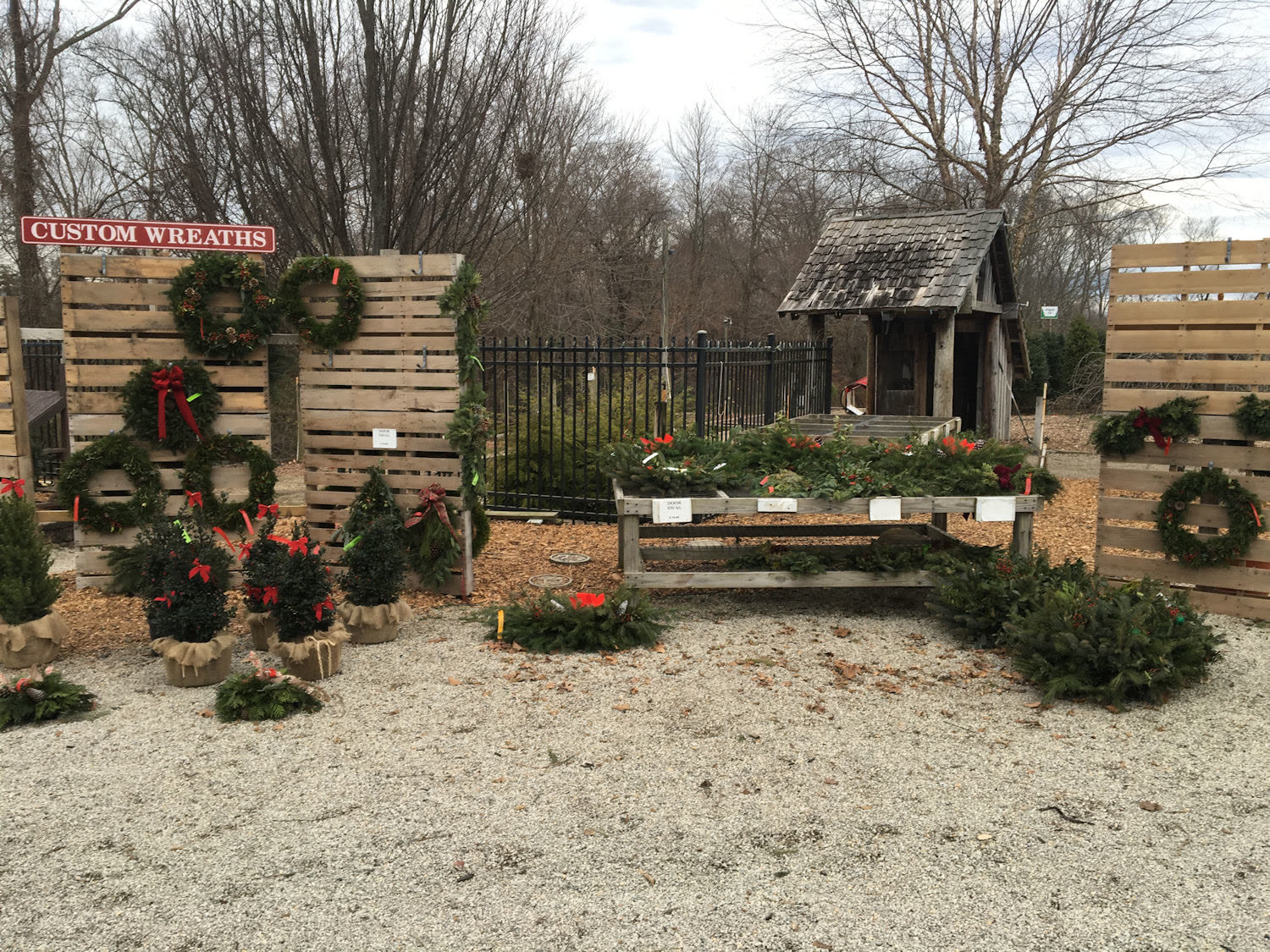 Custom wreaths hanging on a wooden display outside